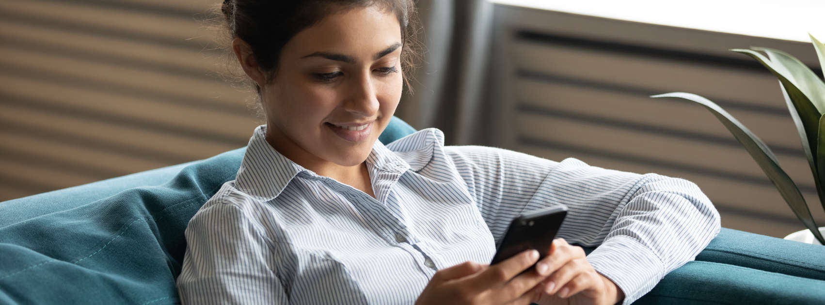 une jeune femme a l'air de sourire sur son smartphone