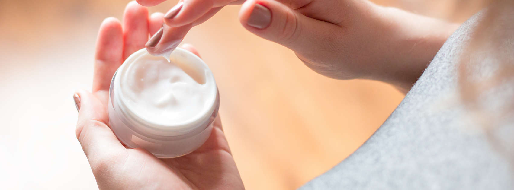 jonge vrouw maakt gebruik van lichaamsverzorging crème